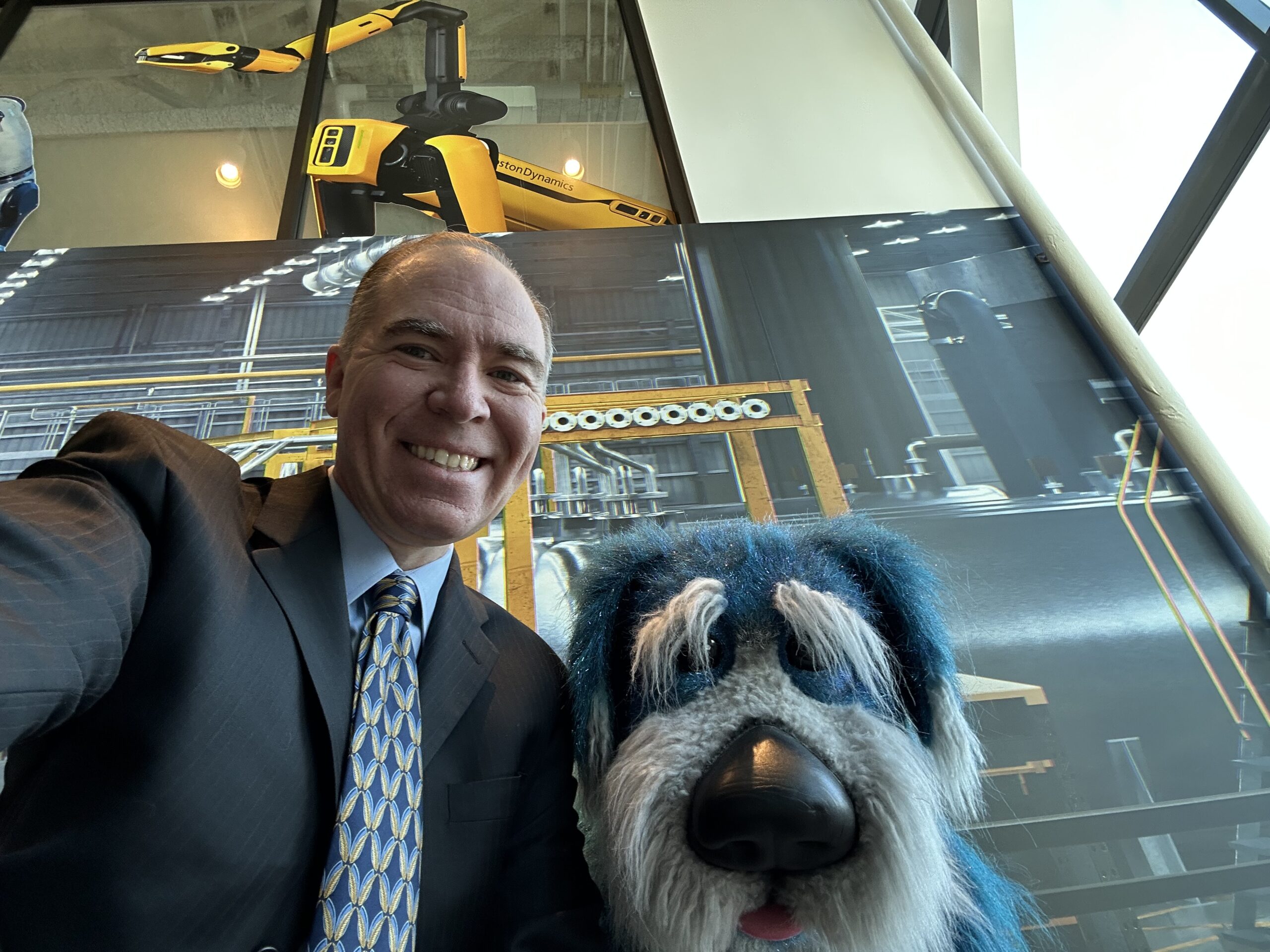 Jason Fiorillo with Boston Dynamics' Spot robot and the company mascot at Boston Dynamics headquarters