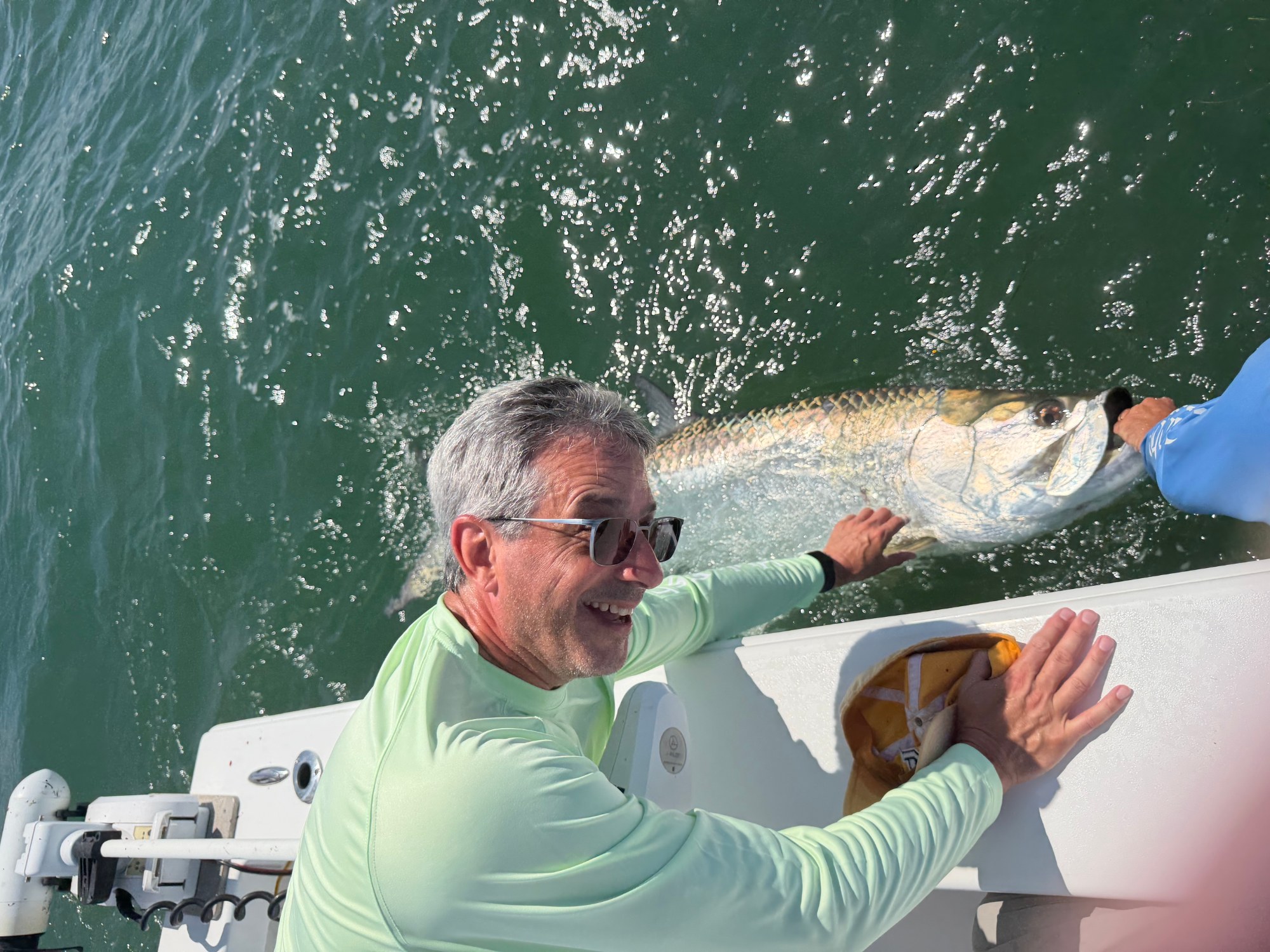 Luis Machado releasing a tarpon boatside.